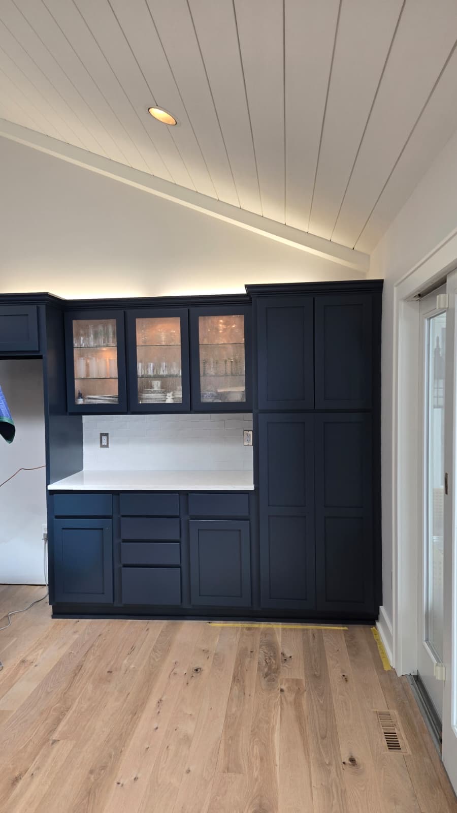 Full kitchen with navy painted cabinets, shiplap ceiling and hardwood floors